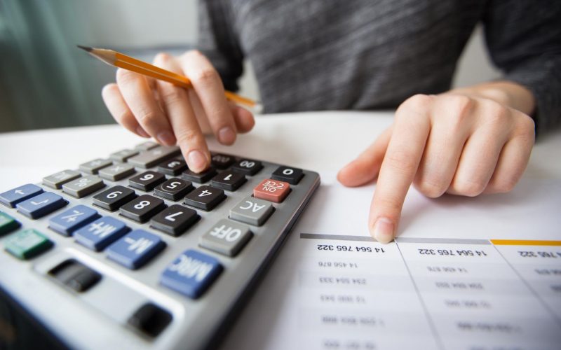 closeup-accountant-hands-counting-calculator