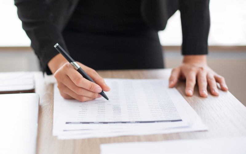 cropped-view-businesswoman-looking-through-list cropped-view-businesswoman-looking-through-list